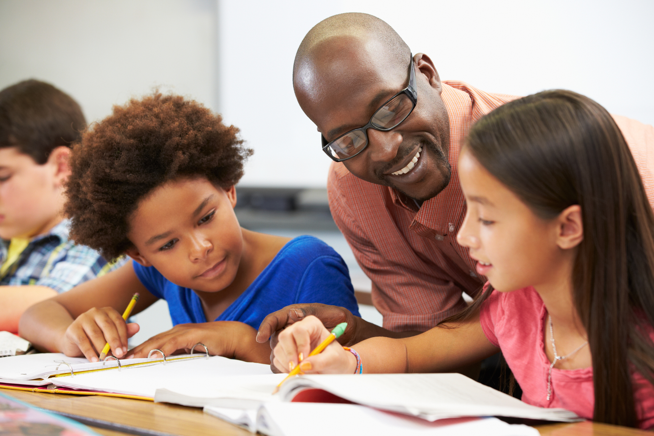 Teacher helping pupils study in the classroom - MNEEP